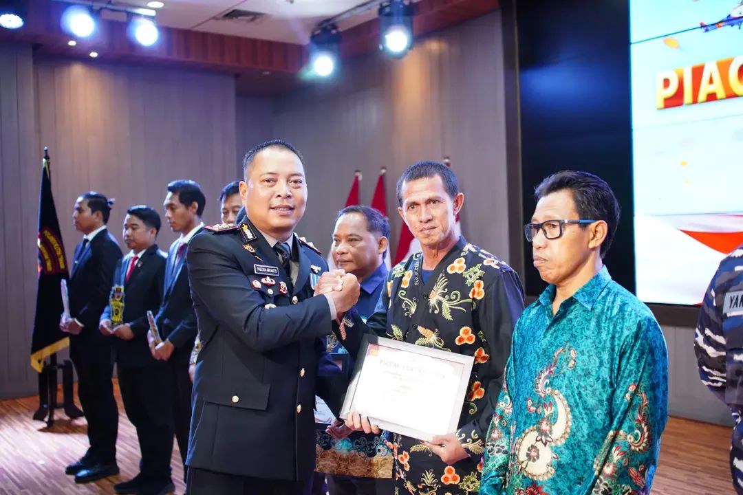 PENYERAHAN PIAGAM PENGHARGAAN SAT KAMLING RT 012 DESA MUKTI JAYA OLEH KAPOLRES KUTAI TIMUR DALAM RANGKA MEMPERINGATI HARI BHAYANGKARA KE-80