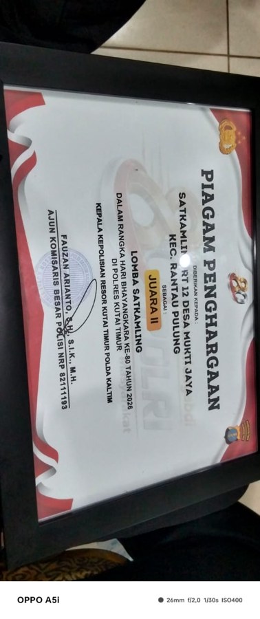 PENYERAHAN PIAGAM PENGHARGAAN SAT KAMLING RT 012 DESA MUKTI JAYA OLEH KAPOLRES KUTAI TIMUR DALAM RANGKA MEMPERINGATI HARI BHAYANGKARA KE-80